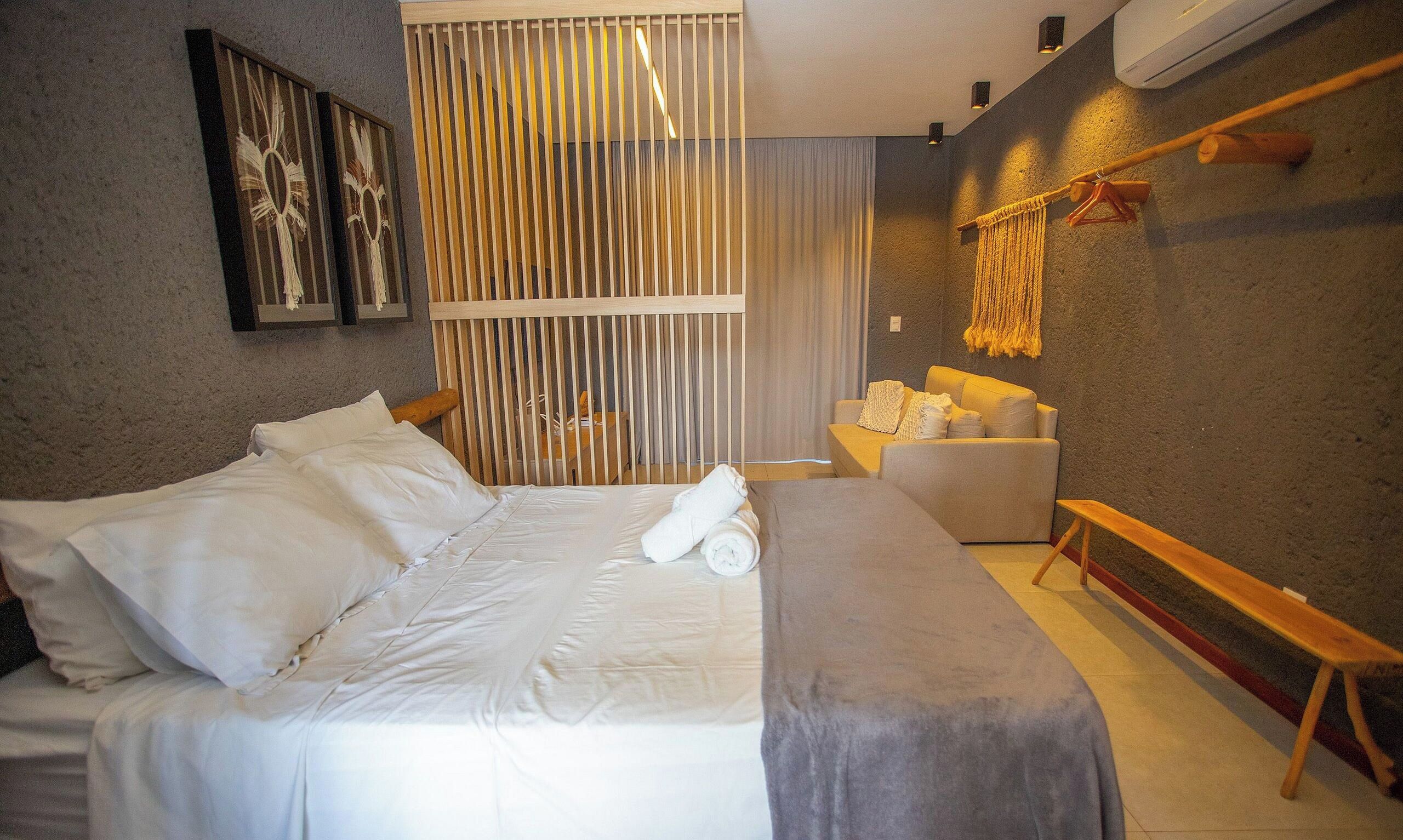 Une chambre à coucher moderne avec un grand lit, un canapé et un banc.
