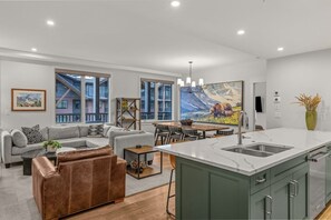 open-concept-living-room-kitchen-island-grizzly-bear-artwork - Modern 4BR|Hot Tub and Mountain Views|Steps from Downtown (Canmore)
