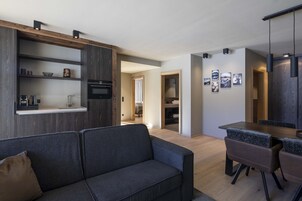 Un espacio habitable moderno con sofá, mesa de comedor y zona de cocina.