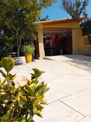 Un edificio con fachada amarilla, entrada empaveda y un letrero que dice 'Villa Bianca'.