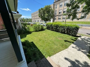 A residential area with a well-maintained lawn, a sidewalk, and a multi-story building in the background. - Niagara Fall NY Brand New Full 3BR 7 Sleep Fully Furnished (Niagara Falls)