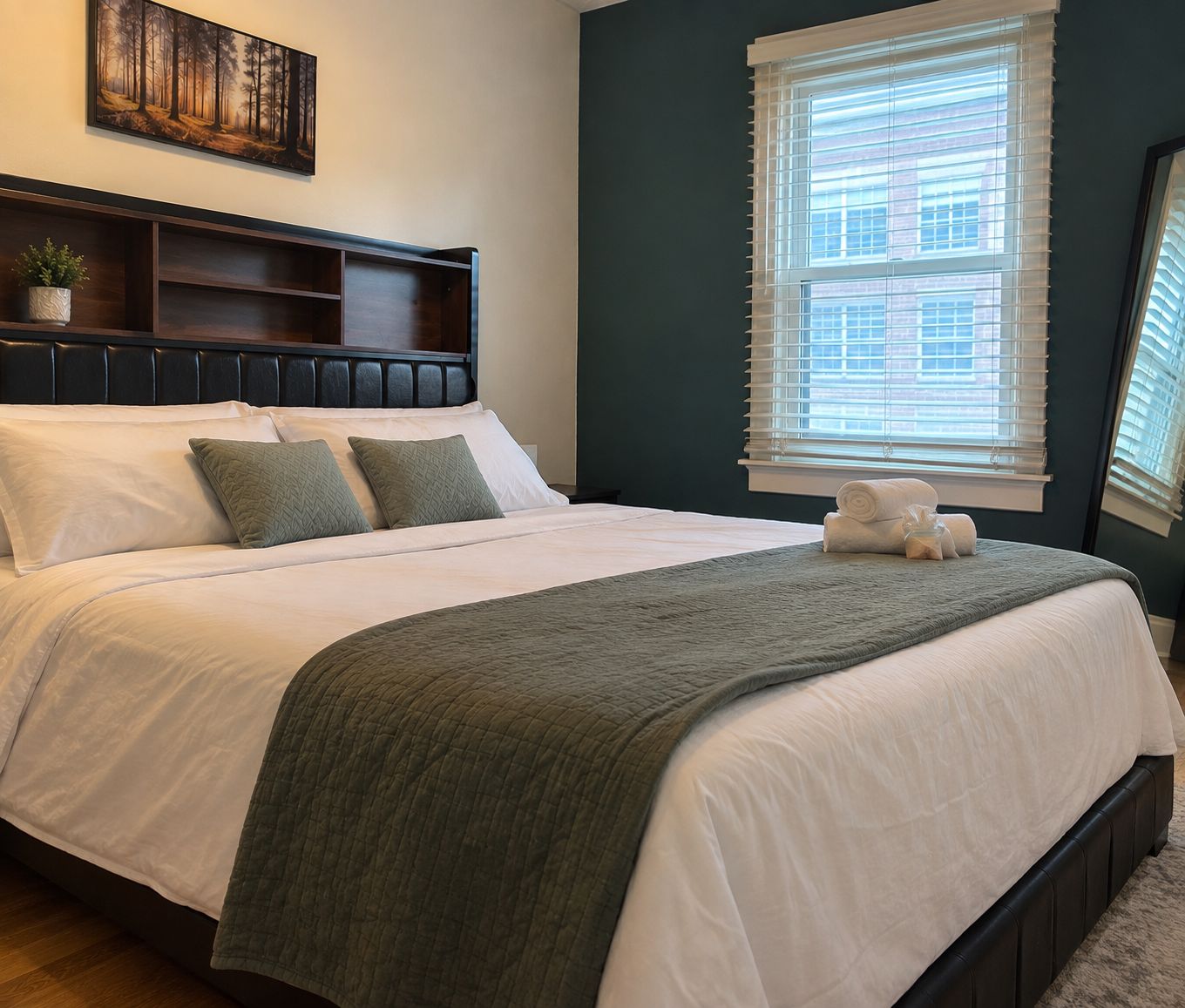 A neatly made bed with a headboard, pillows, and a blanket.