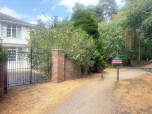 A gated entrance with a brick wall and a sign indicating a no BBQs or fires policy.