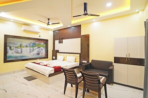 Un dormitorio moderno con cama, escritorio, dos sillas, armario y un cuadro en la pared.