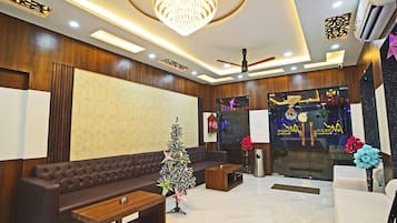 A modern lobby with a chandelier, a seating area, and a Christmas tree.