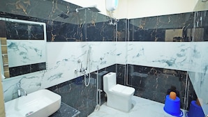 A bathroom with a white sink, a toilet, a shower, and a mirror.