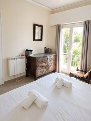 A hotel room with a bed, a dresser, a radiator, and a window with curtains. - Apartment 'Vue Sur Mer' with Shared Terrace (Cannes)