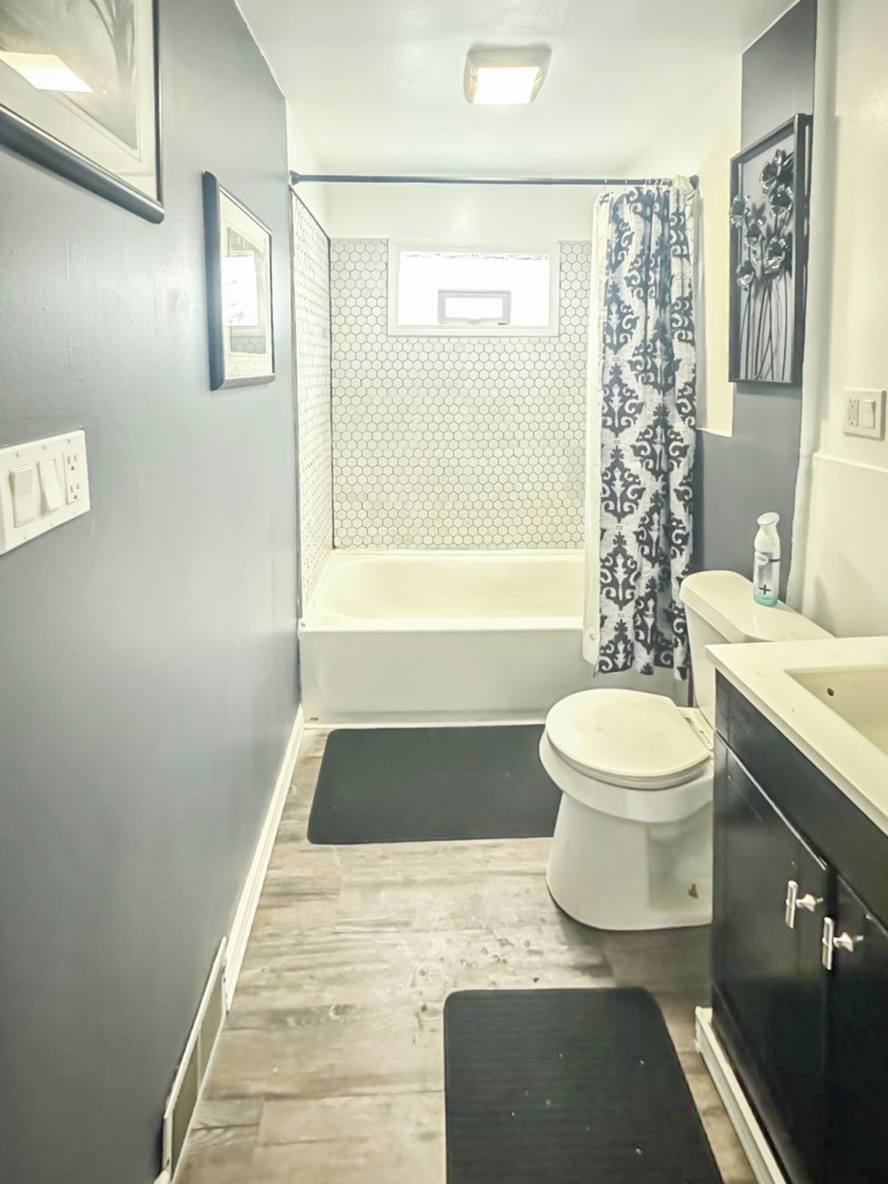A bathroom with a bathtub, toilet, and vanity.