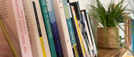 A bookshelf with various books, a potted plant, and a wooden shelf.
