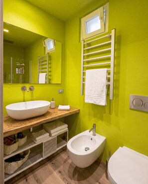 A modern bathroom with a large oval sink, a bidet, a towel rack, and a mirror. - Casa Mille e una Stella: Rooftop Terrace & Open-Sky-Room (Siracusa)