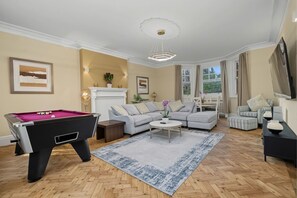 A living room with a pool table, a sofa set, a coffee table, and a fireplace. - Holland Park 5BR 3BA Stay With Private Sauna (London)