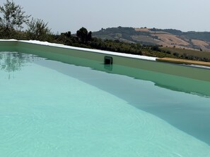 Uma piscina com vista clara para uma paisagem montanhosa ao fundo.