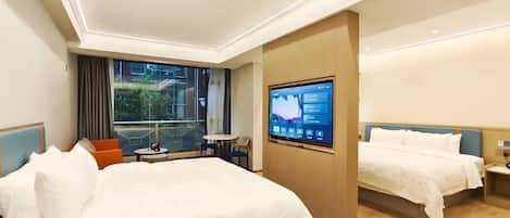 A hotel room with two beds, a TV, a balcony, and a small table with chairs.