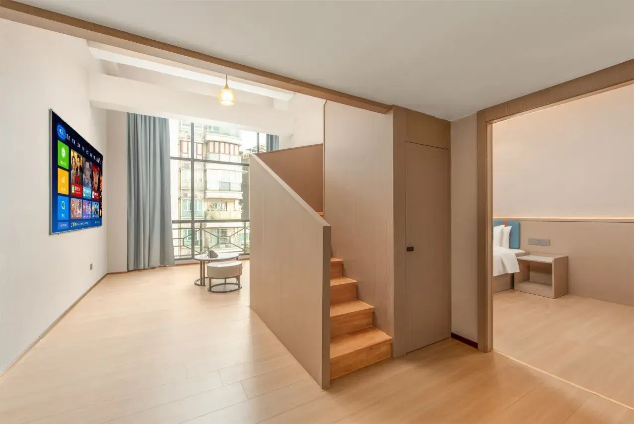 A modern interior with a staircase, a dining area, and a view through large windows.
