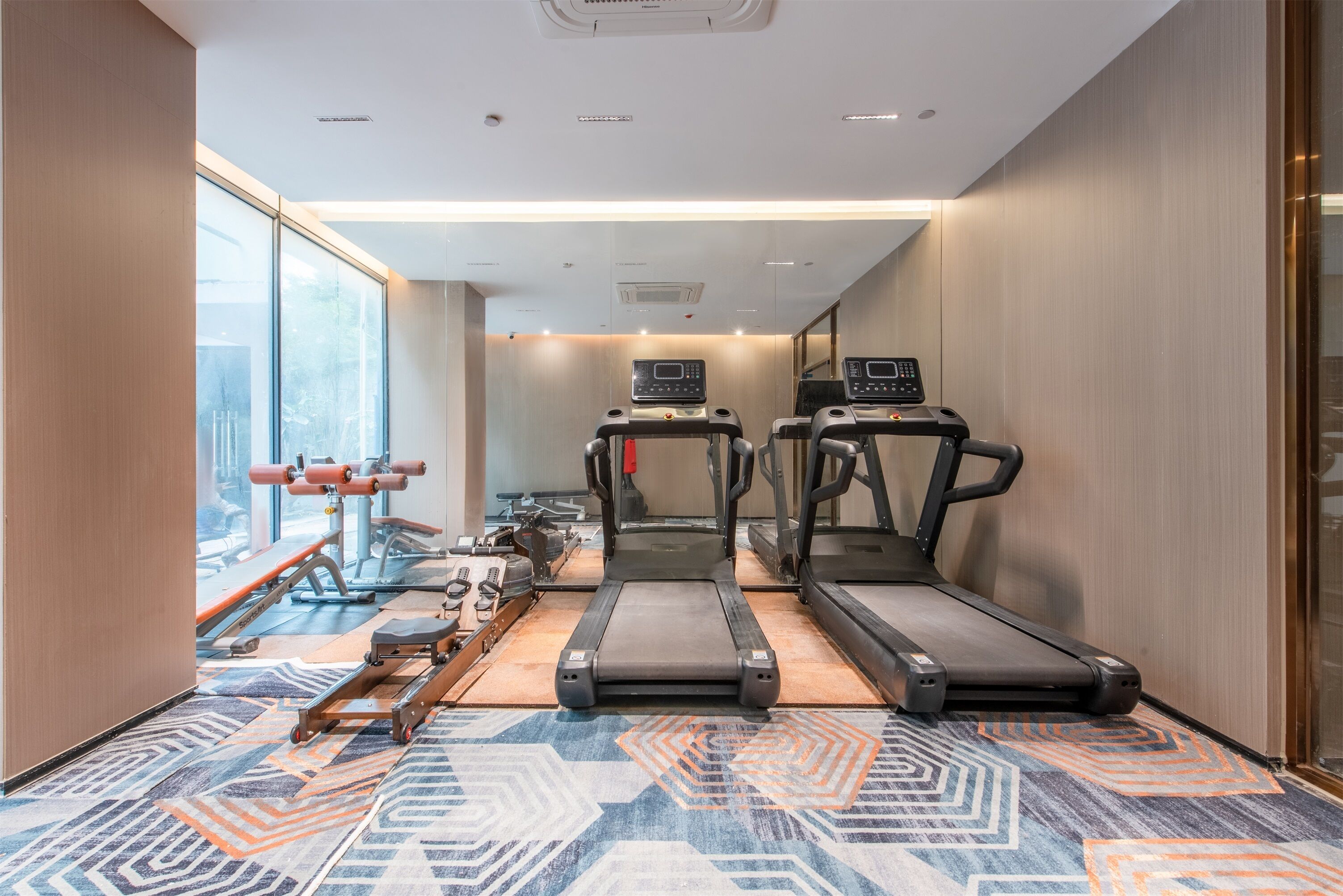 A gym with treadmills, exercise bikes, and weights.