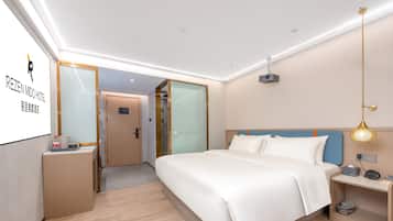 Ein Hotelzimmer mit Bett, Nachttisch und Schreibtisch mit Stuhl.