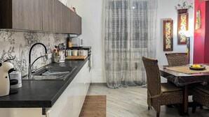 Una cocina moderna con microondas integrado, un lavamanos y un comedor con mesa y sillas.
