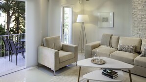 Ein modernes Wohnzimmer mit Sofa, Sessel, Couchtisch und Stehlampe.