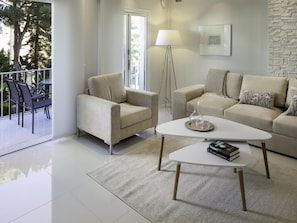 A modern living room with a sofa, armchair, coffee table, and a floor lamp. - 1 Dormitorio Andalucia del Mar Ref 209 (Marbella)