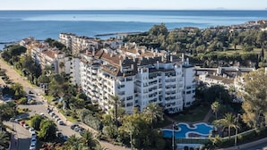 A coastal hotel with multiple floors, a swimming pool, and a view of the sea. - 2 Dormitorios Medina Garden Ref 623 (Marbella)