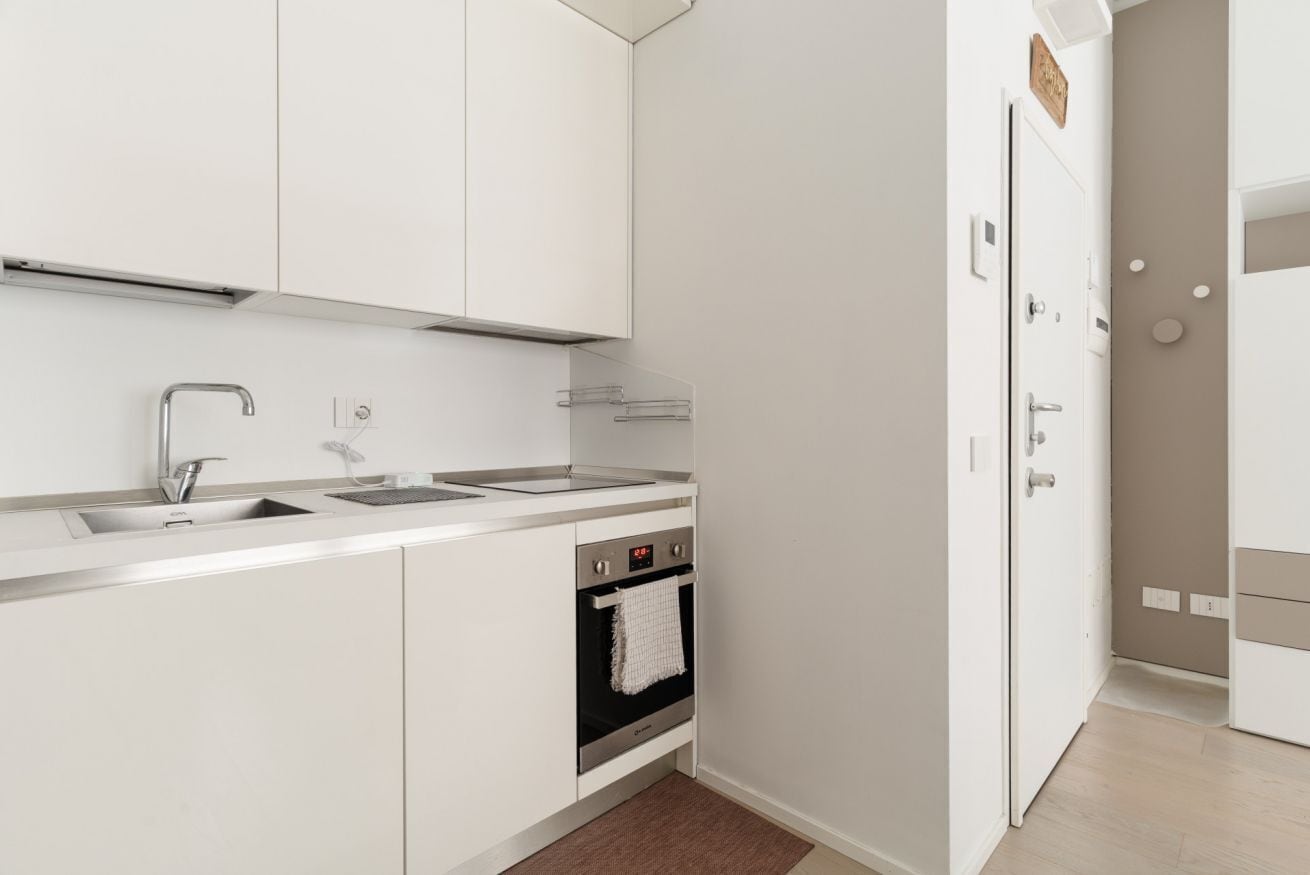 Eine moderne Küche mit Einbauofen, Spüle und Arbeitsplatte.