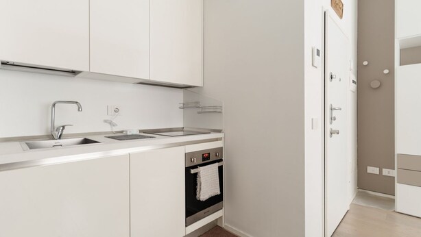 A modern kitchen with a built-in oven, a sink, and a countertop. - GuestHost - Cozy Apartment in Darsena, Near the Navigli (Milan)