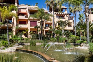 A multi-story hotel with a pool area featuring a small waterfall. - Apto Bah a de Alc Ntara San Pedro (Marbella)