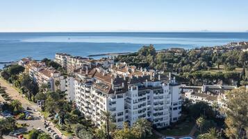 Un hotel frente al mar, con varios pisos, piscina y vistas al océano.
