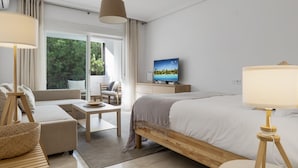 Een moderne hotelkamer met een bed, een slaapbank, een bureau en een televisie.