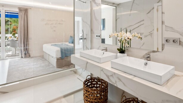 A modern bathroom with a large mirror, two sinks, and a shower area. - 2 Dormitorios Playas del Duque Ref 228 (Marbella)