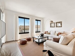 A modern living room with a sofa, coffee table, ottomans, and a TV. - OPQ Central Ban s (Marbella)