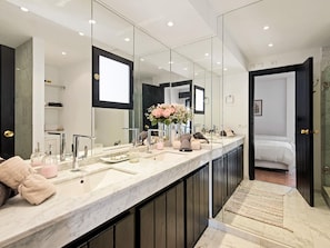 A modern bathroom with a large mirror, a marble countertop, and a visible shower area. - OPQ Central Ban s (Marbella)