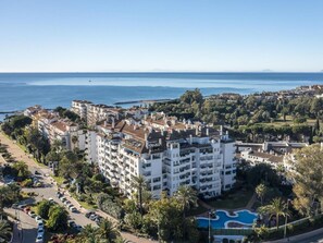 Ein Hotel an der Küste mit mehreren Etagen, einem Schwimmbad und Meerblick.