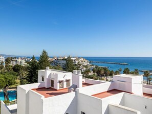 Ein Küstenwohngebiet mit weißen Gebäuden, blauem Himmel und Blick aufs Meer.