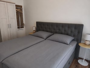 A bed with grey bedding, a grey upholstered headboard, and two bedside tables with lamps. - 120-square-meter vacation rental with lake views, dock right on the water / Sleeps 8, 3 bedrooms (Neukieritzsch)