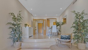 A spacious hallway with a dining area, a kitchen, and a seating area with a round rug. - Mimosas de Ban s 10 2 2 E (Marbella)