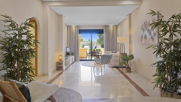 A modern living room with a sofa, chairs, a coffee table, and a dining area with a table and chairs. There are potted plants and a painting on the wall. - Mimosas de Ban s 10 2 2 E (Marbella)