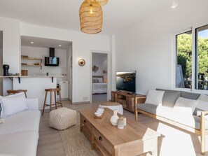 Ein modernes Wohnzimmer mit einer Couch, einem Couchtisch und einem Fernseher.