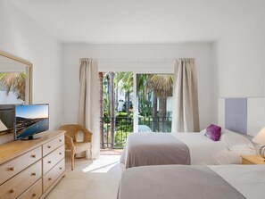 A hotel room with a balcony, a TV, a bed with a pillow, and a dresser. - Jardines de Aldaba 412 (Marbella)