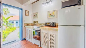 A kitchen with a built-in oven, a microwave, a toaster, and a refrigerator.