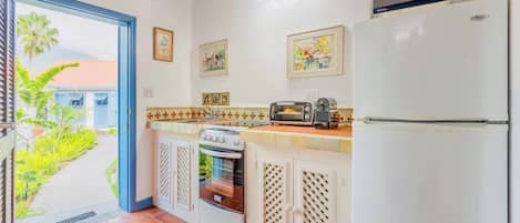 A kitchen with a built-in oven, a microwave, a toaster, and a refrigerator.
