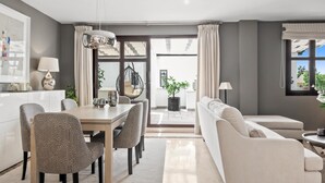 A modern living room with a dining area, a sofa, and a hanging chair. - Privilegio Marbella (Marbella)