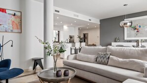 A modern living room with a sofa, coffee table, and a vase with flowers. - Privilegio Marbella (Marbella)