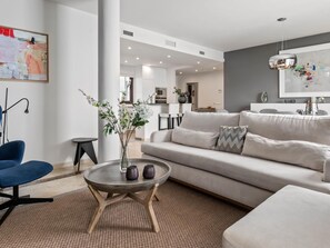 A modern living room with a sofa, coffee table, and a vase with flowers. - Privilegio Marbella (Marbella)