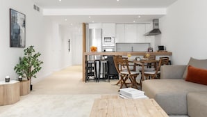 A modern apartment with a dining area, kitchen, and living space. - Amplio Apartamento 3 Dormitorios Playas del Duque (Marbella)