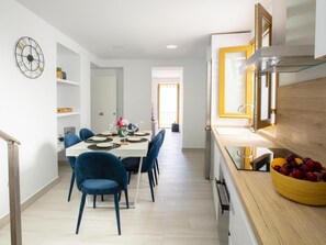 A modern kitchen with a wooden countertop, a stainless steel range hood, and a bowl of fruit. - Calle Pintado 21 Atico (Estepona)