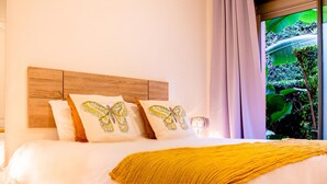 Uma cama com cabeceira de madeira, roupa de cama branca e um cobertor amarelo.