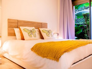 Ein Bett mit einem hölzernen Kopfteil, weißer Bettwäsche und einer gelben Tagesdecke.