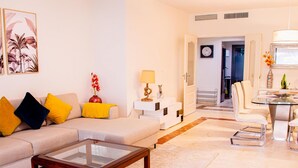 Uma sala de estar moderna com um sofá, mesa de centro e área de jantar.