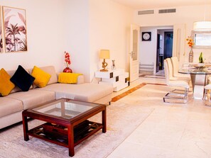 Ein modernes Wohnzimmer mit Sofa, Couchtisch und Essbereich.